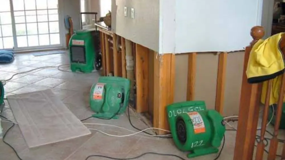 Drying equipment running in a room with the lower wall cut open for repair